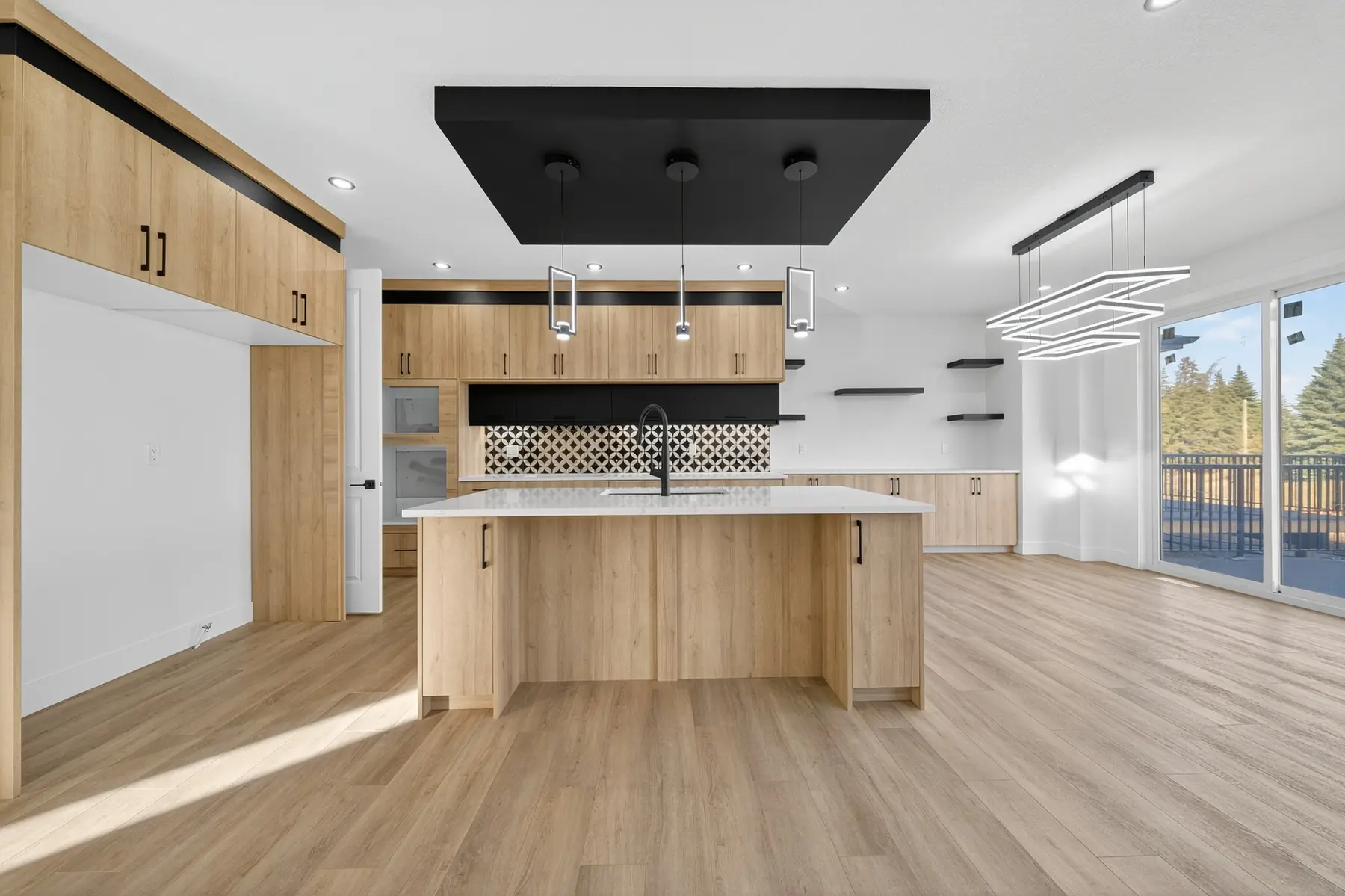 Kitchen with warm wood cabinetry, black accents and a large island in the Cavanagh residence
