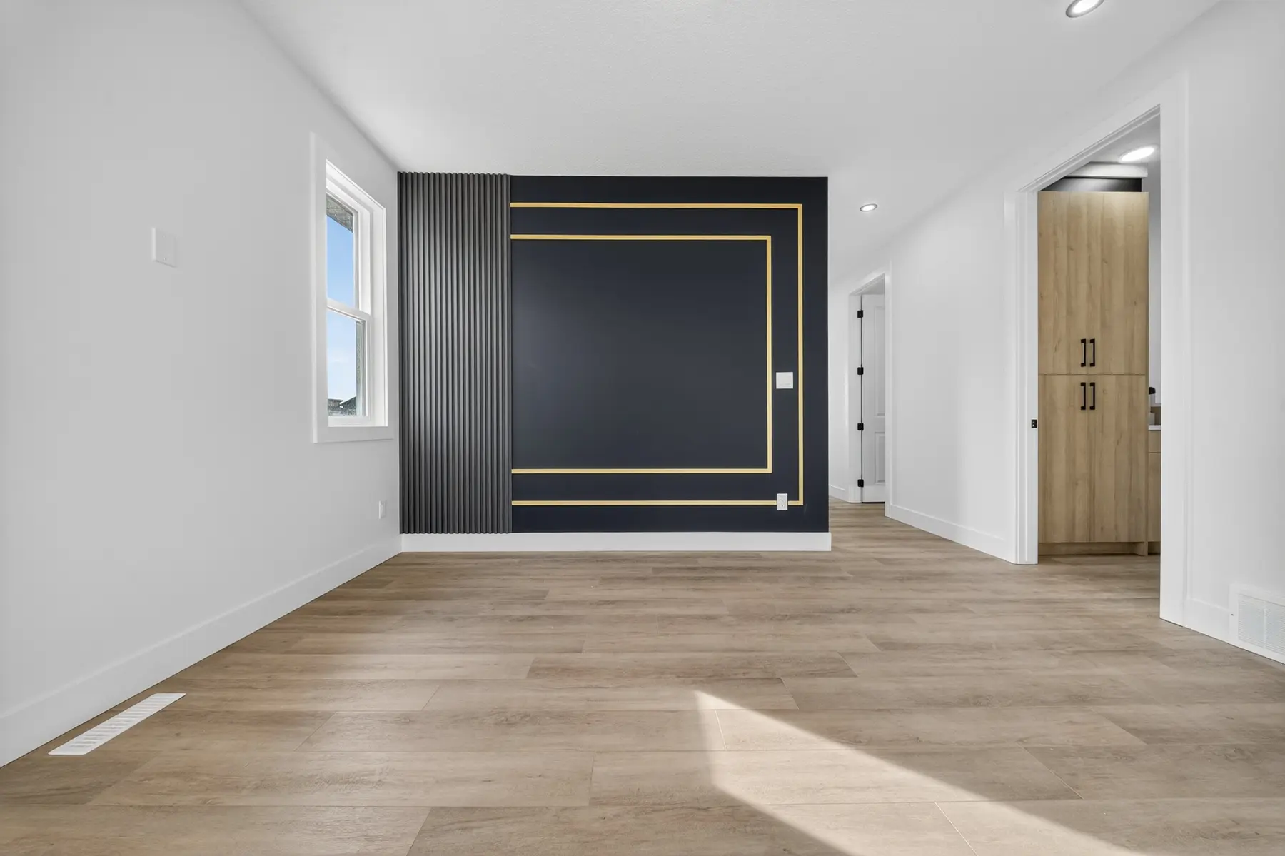 Bonus room with black, wood and gold feature-wall details in the Cavanagh residence