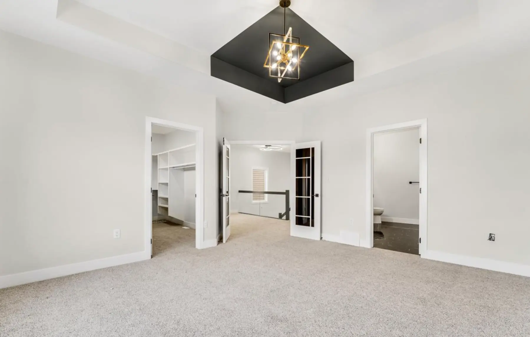 Primary bedroom with a recessed black ceiling detail and walk-in closet in the Laurel residence