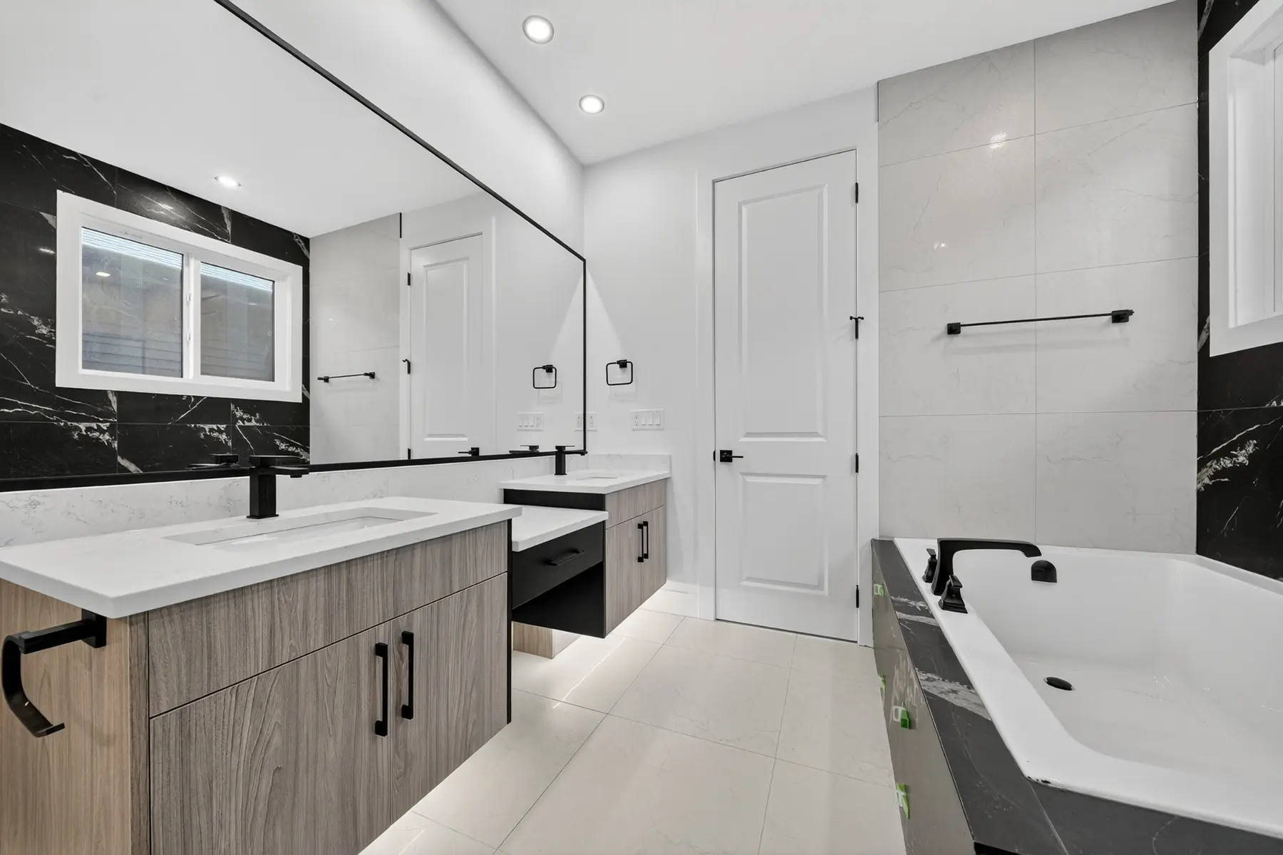 Primary ensuite with double vanity and tiled tub surround in the Cavanagh residence